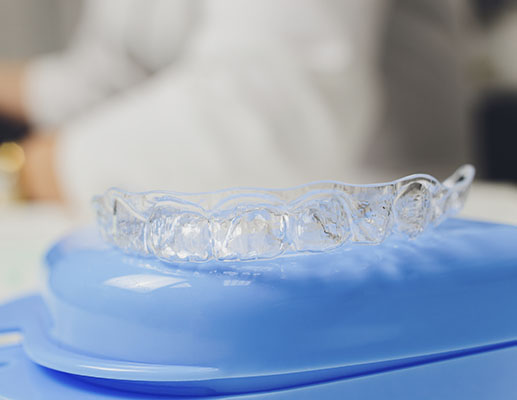 A patient inserting a clear aligner tray